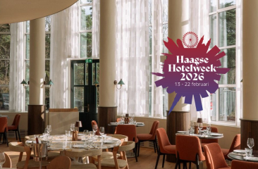 Inrichting van een moderne eetzaal met ronde tafel en stoelen, verlichting en grote ramen.