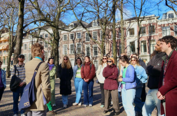 Toeristen luisteren naar een gids in een park.