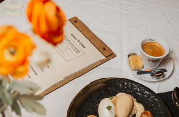 Menukaart met kopje koffie, dessert en oranje bloemen