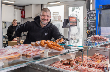 Marktverkoper met producten op een toonbank op de Haagse Markt