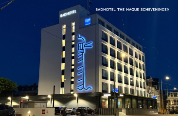 Modernes Hotel mit blauer Beleuchtung bei Nacht.
