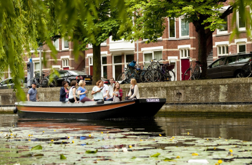 Een sloep vaart in een gracht in Den Haag