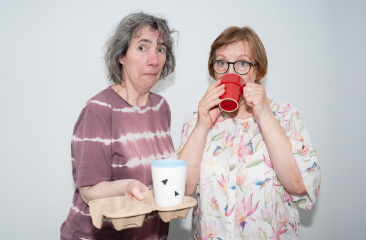 Twee vrouwen met bekers en verbaasde gezichten