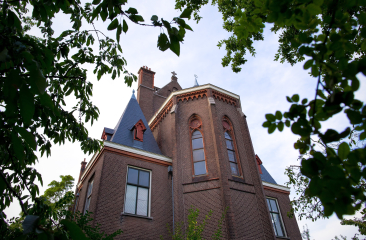 Bovenkant van de Barthkapel door groene takken heen gefotografeerd.