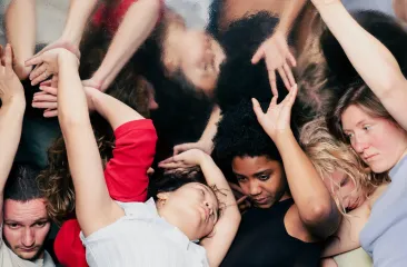 Vijf mensen contortioneren zich met elkaar, hun handen en armen zijn met elkaar verweven. (c) Peteris Viksna