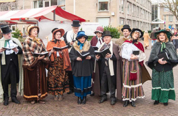 Eine Gruppe von Menschen in historischer Kleidung singt zusammen
