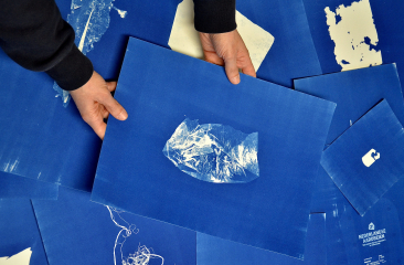 Iemand houdt een blauwe afdruk met een transparante afbeelding vast