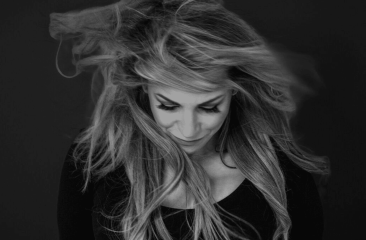 Vrouw met lang, wapperend haar kijkt naar beneden