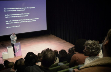Spreker op filosofische avond in theaterzaal