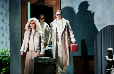 Drie reizigers met koffers in theatrale setting