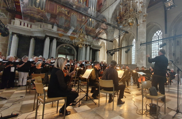 Koor en orkest tijdens uitvoering in monumentale kerk