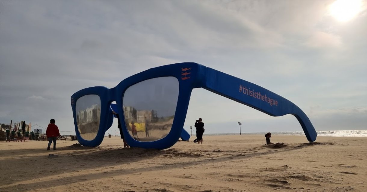 Grote blauwe zonnebril op het strand van Scheveningen Grote blauwe zonnebril op het strand van Scheveningen