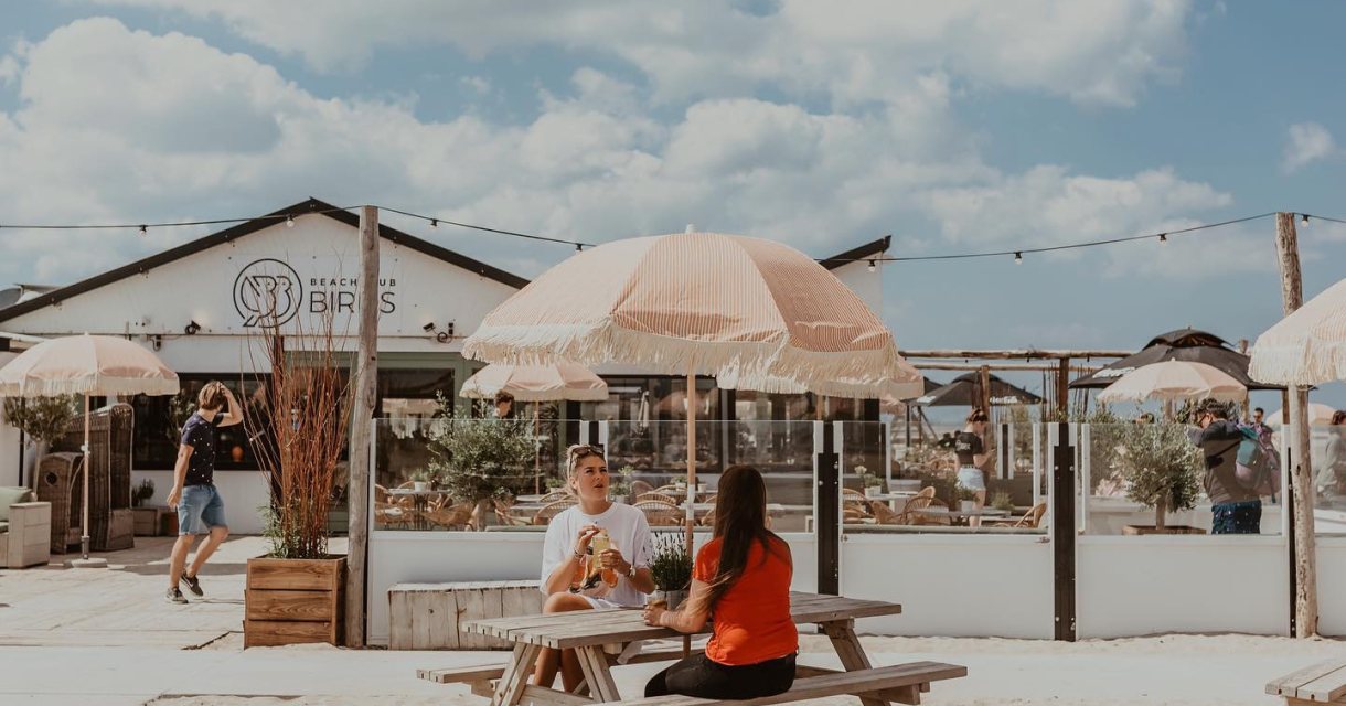 Houten en rieten meubels, jaren 70 parasols op het strand, kortom bij Beachclub Birds beleef je een echte strandvibe. Houten en rieten meubels, jaren 70 parasols op het strand, kortom bij Beachclub Birds beleef je een echte strandvibe.