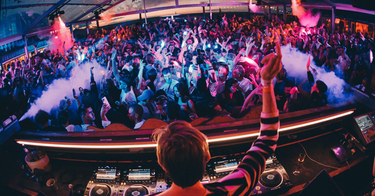 Drukke dansvloer met DJ in een feestelijke sfeer