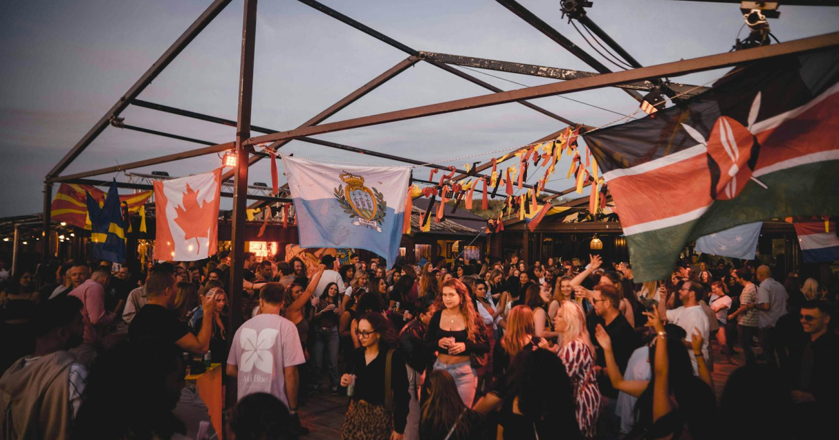 Feestende mensen onder vlaggen op openlucht locatie