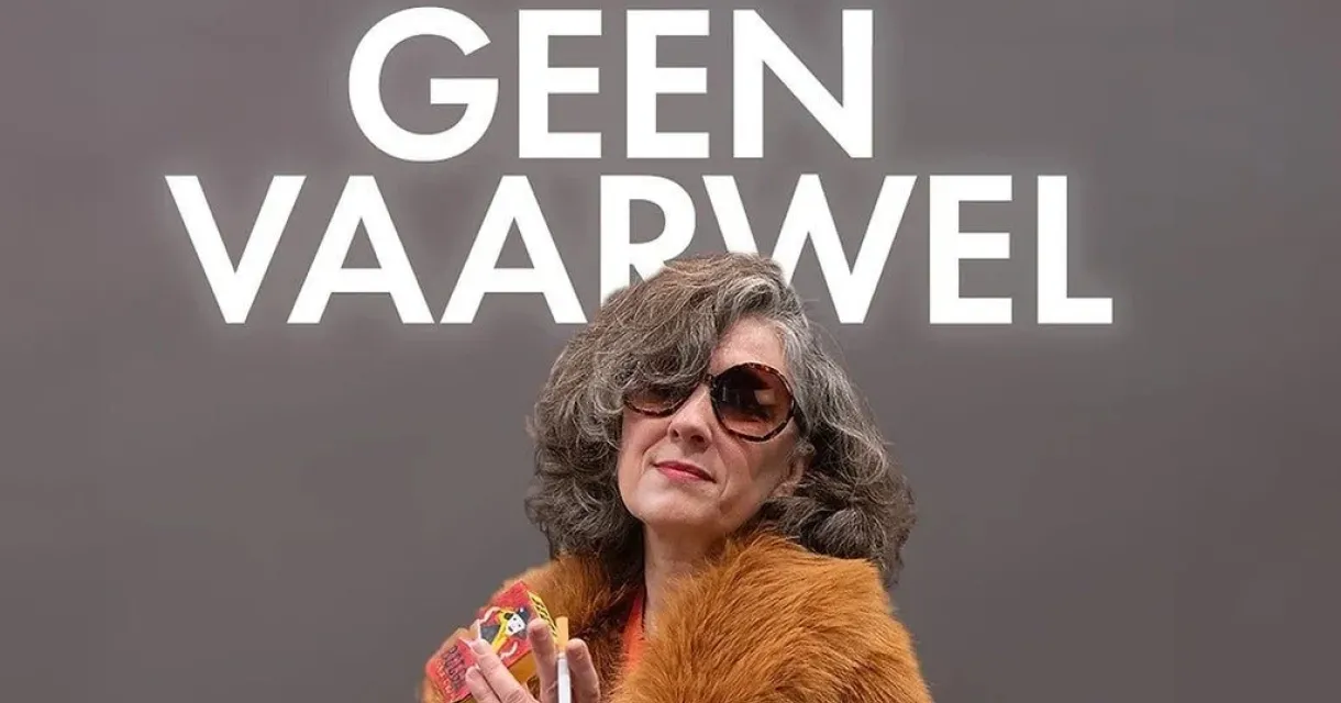 Naomi Inez Wielinga poseert voor een grijze achtergrond met de titel van haar show: Geen Vaarwel. Ze draagt een bruine bontjas en zonnebril. Naomi Inez Wielinga poseert voor een grijze achtergrond met de titel van haar show: Geen Vaarwel. Ze draagt een bruine bontjas en zonnebril.