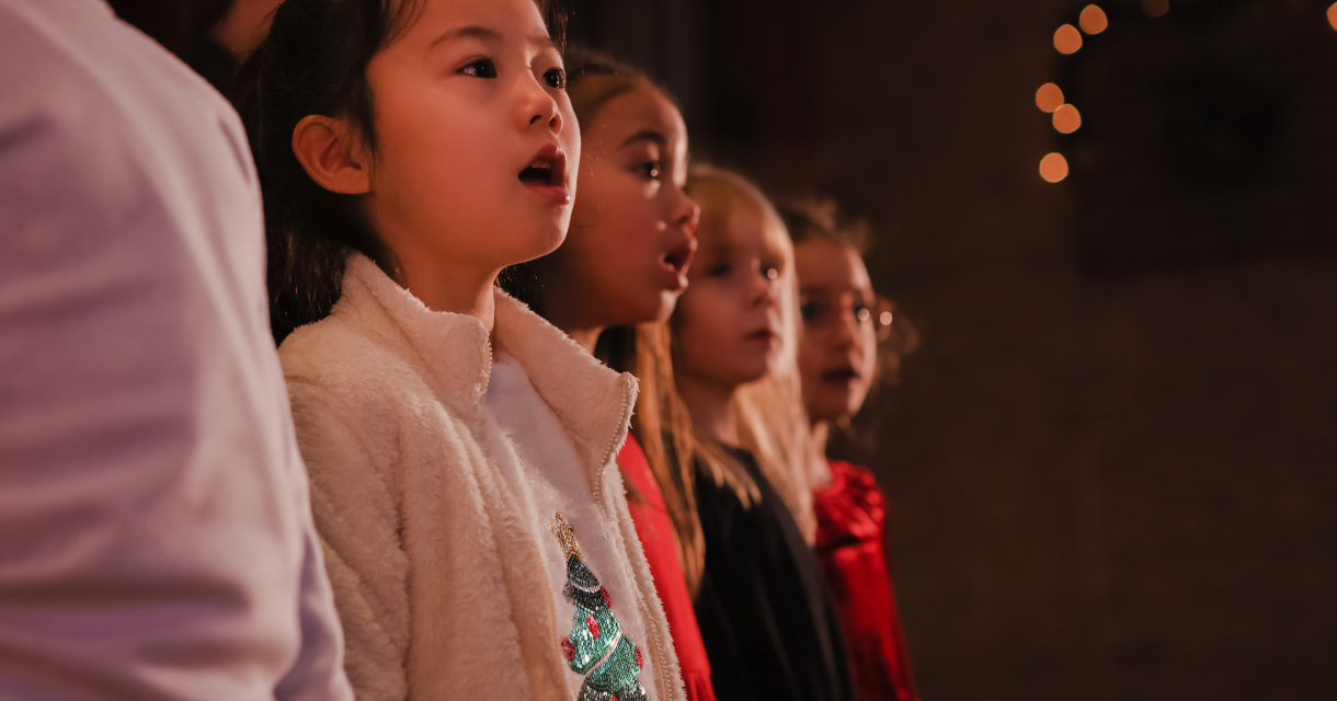 Jong meisje in het koor die kerst liederen zingt 