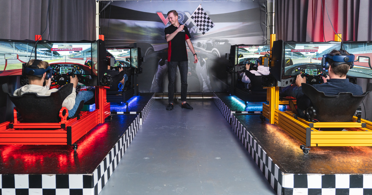 Vier deelnemers in een race simulator starten een race Vier deelnemers in een race simulator starten een race