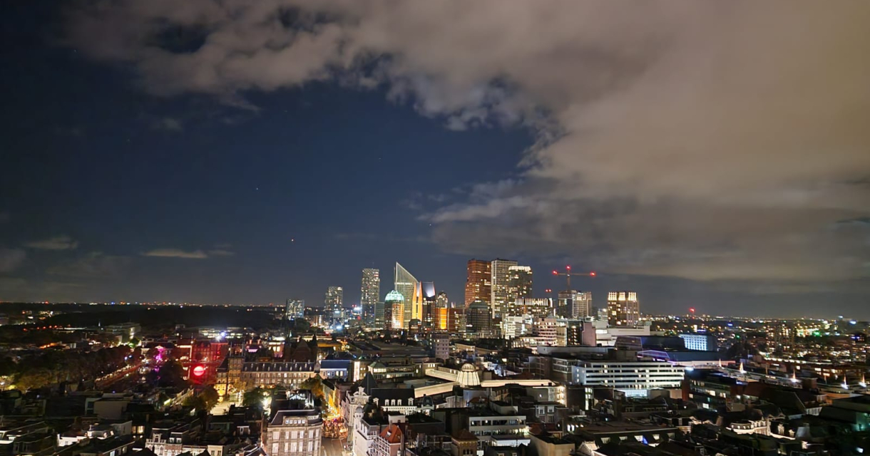 Spectaculair uitzicht over de verlichte skyline in een donker Den Haag vanaf De Haagse Toren