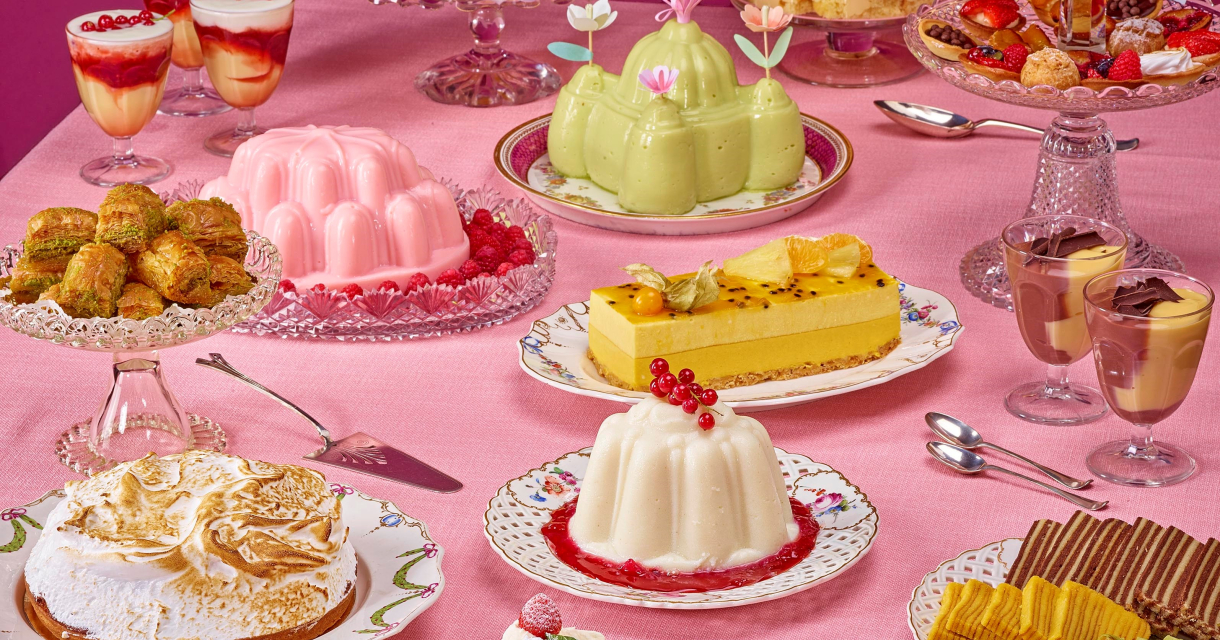 Een tafel vol met toetjes, taartjes en andere lekkernijen