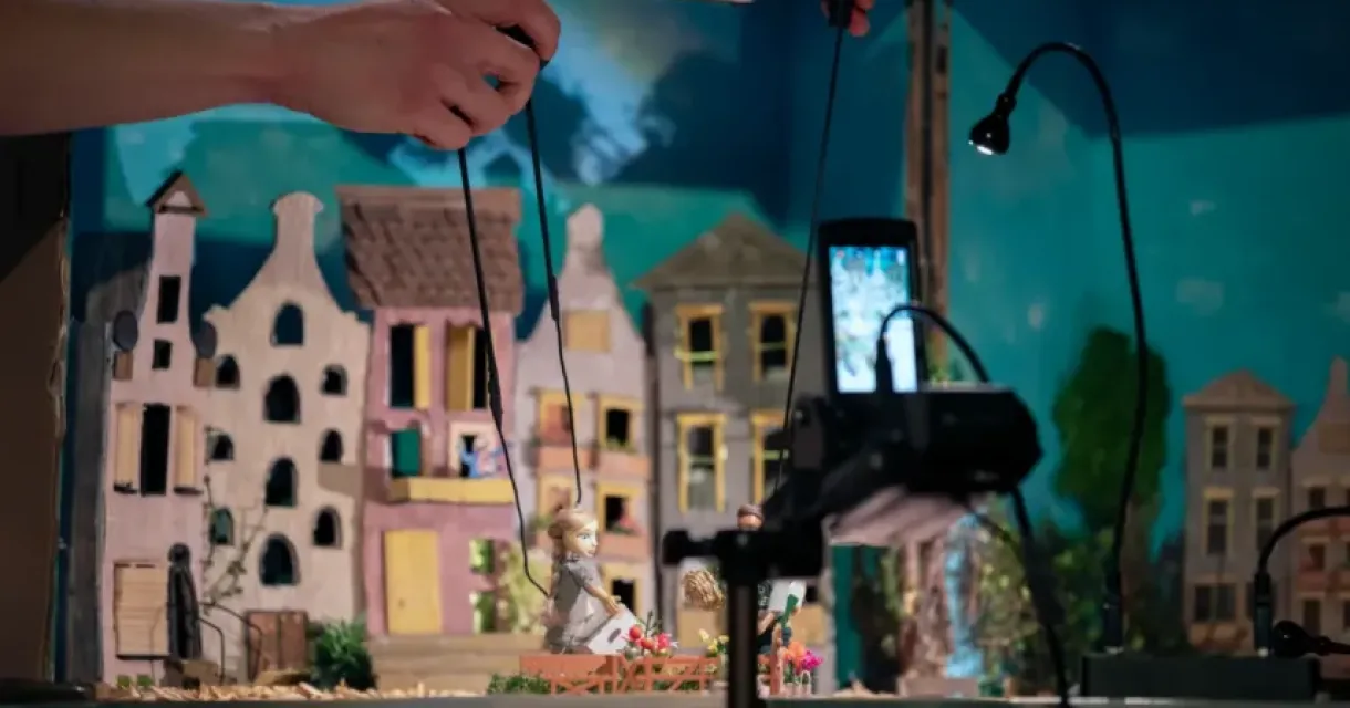 Een miniatuurtheaterset met marionettenpoppen en een decor van kartonnen huizen Een miniatuurtheaterset met marionettenpoppen en een decor van kartonnen huizen