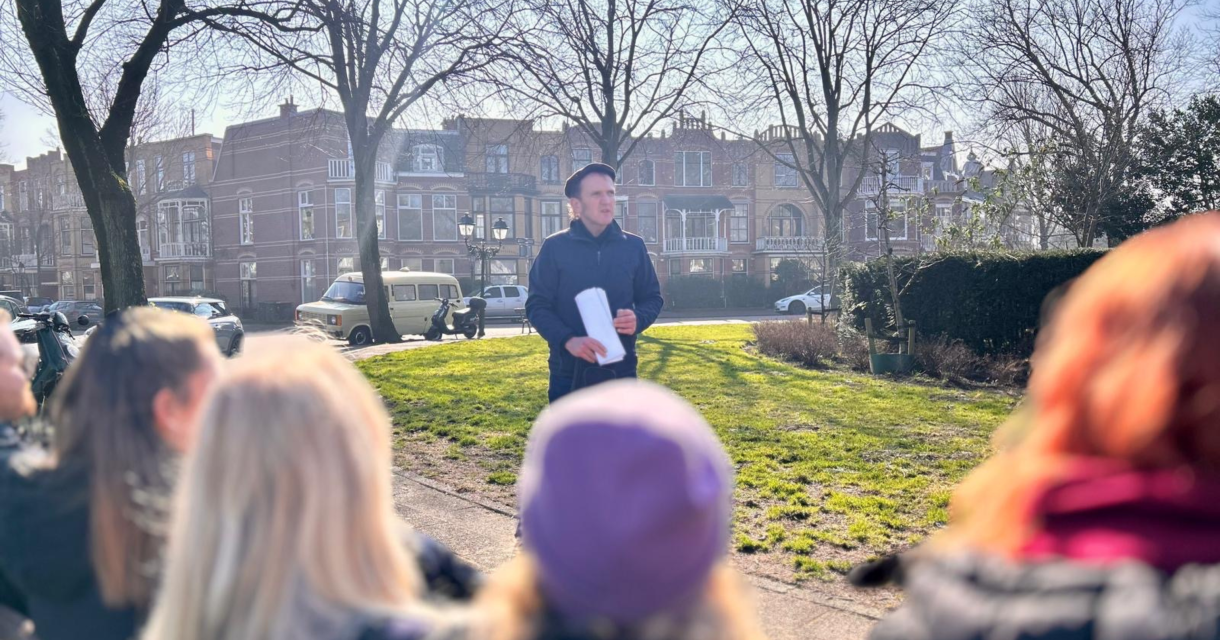Gids Arie Spaans die wat uitlegt aan de deelnemers van de wandeling. 
