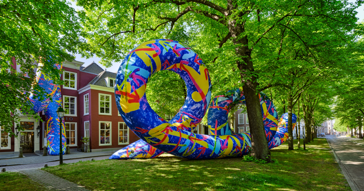 Kleurrijk kunstwerk op het Lange Voorhout tussen de bomen voor de gevel van Pulchri Studio