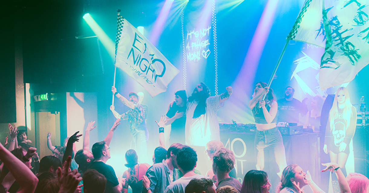 Sfeerbeeld met podium waarop de emo scene krachtig meezingt wapperend met vlaggen en leuzen. Sfeerbeeld met podium waarop de emo scene krachtig meezingt wapperend met vlaggen en leuzen.