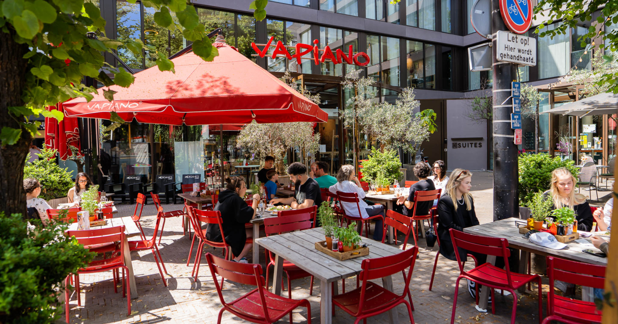 Het terras van Vapiano een het Buitenhof in Den Haag met rode stoeltjes en rode parasols Het terras van Vapiano een het Buitenhof in Den Haag met rode stoeltjes en rode parasols