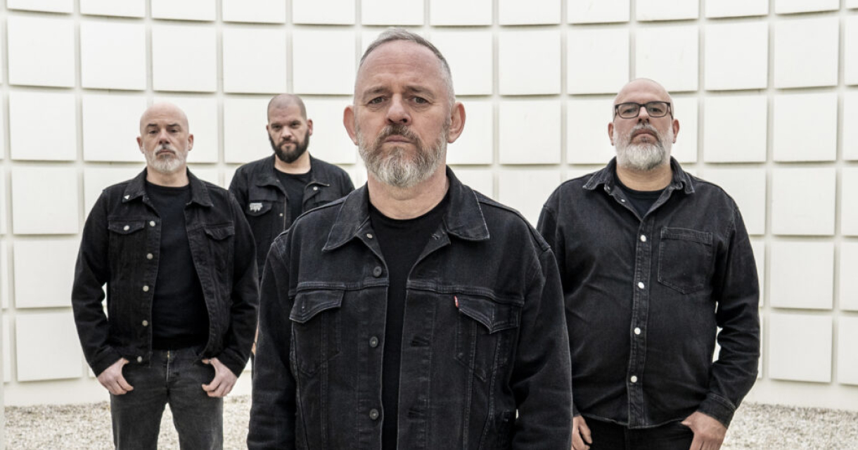 De Belgische band Hemelbestormer poseert in zwart-wit, gehuld in donkere kleding, tegen een minimalistisch geometrisch decor, even krachtig en gelaagd als hun muziek. De Belgische band Hemelbestormer poseert in zwart-wit, gehuld in donkere kleding, tegen een minimalistisch geometrisch decor, even krachtig en gelaagd als hun muziek.