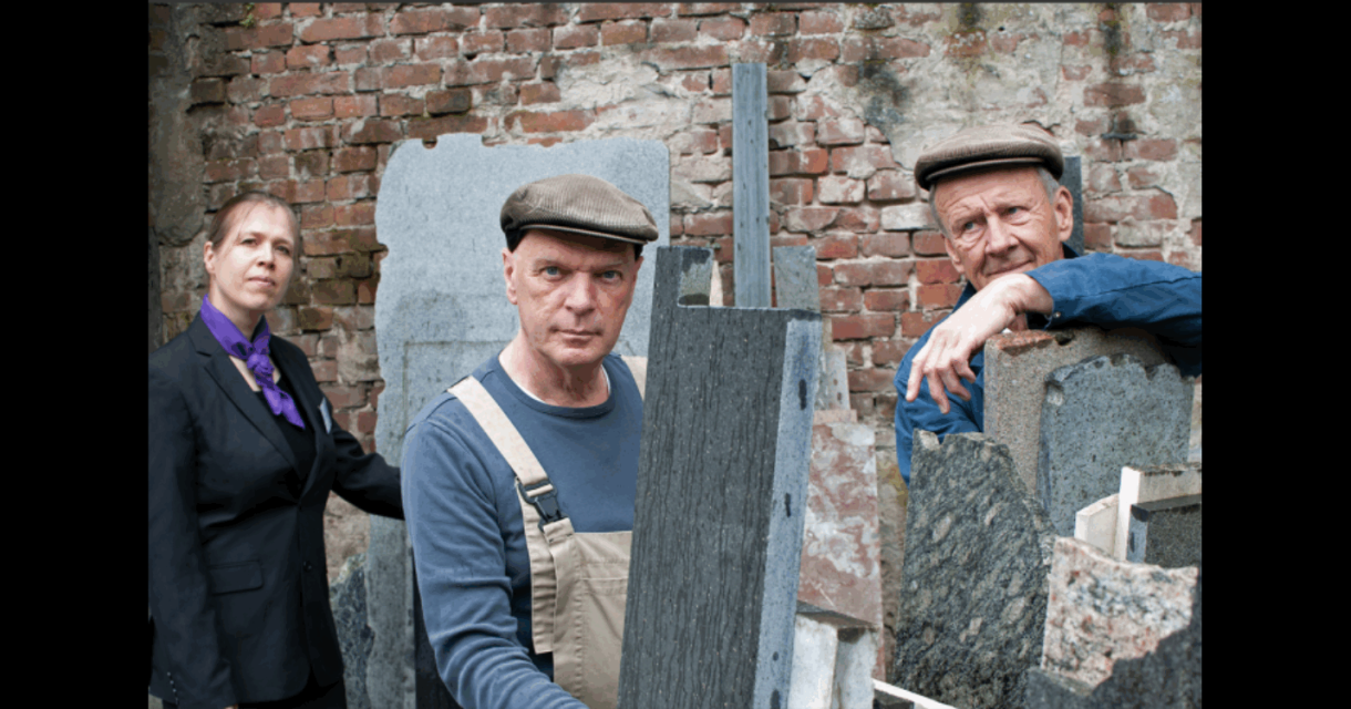 Drie muzikanten tussen grafstenen en een bakstenen muur Drie muzikanten tussen grafstenen en een bakstenen muur