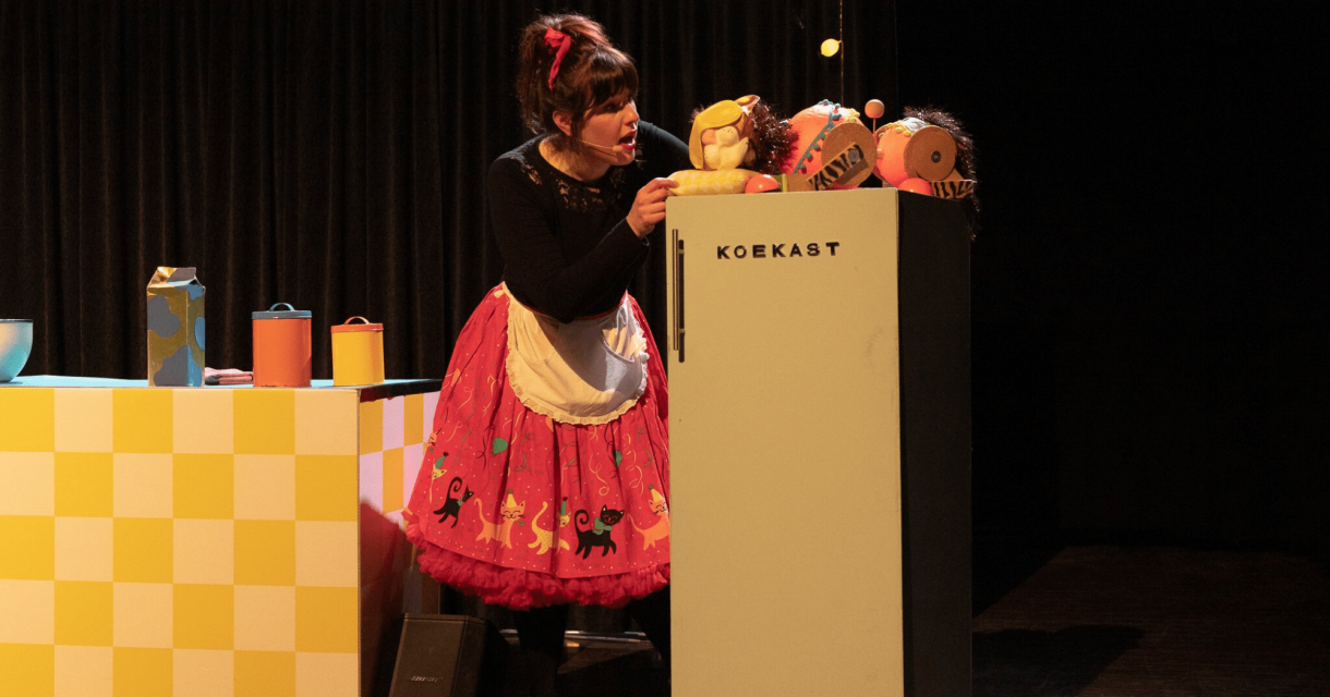 Vrouw in theaterkeuken opent 'koekast' met poppen (c) Laros & de jong beeldmakerij Vrouw in theaterkeuken opent 'koekast' met poppen (c) Laros & de jong beeldmakerij