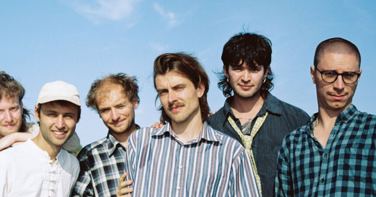 Groepsfoto van band Astronaut met op de achtergrond wolken, omdat je met hen meekijkt naar de aarde.