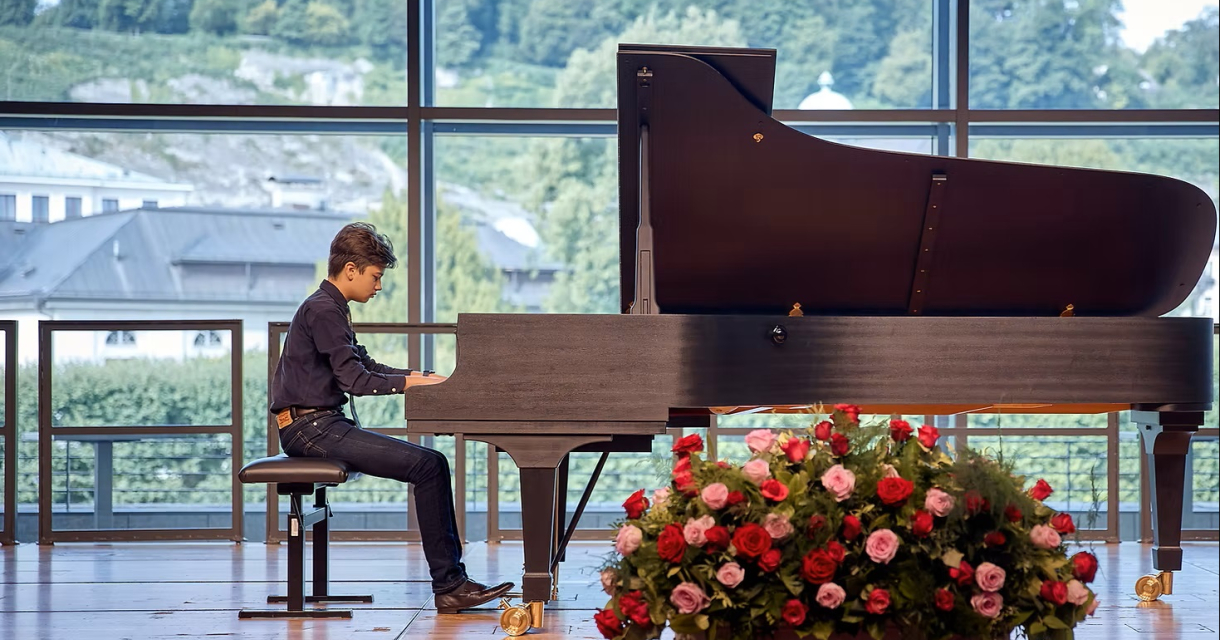 Pianist Christian Gillisen spelend achter vleugel met een bos roze en rode rozen ervoor. Pianist Christian Gillisen spelend achter vleugel met een bos roze en rode rozen ervoor.