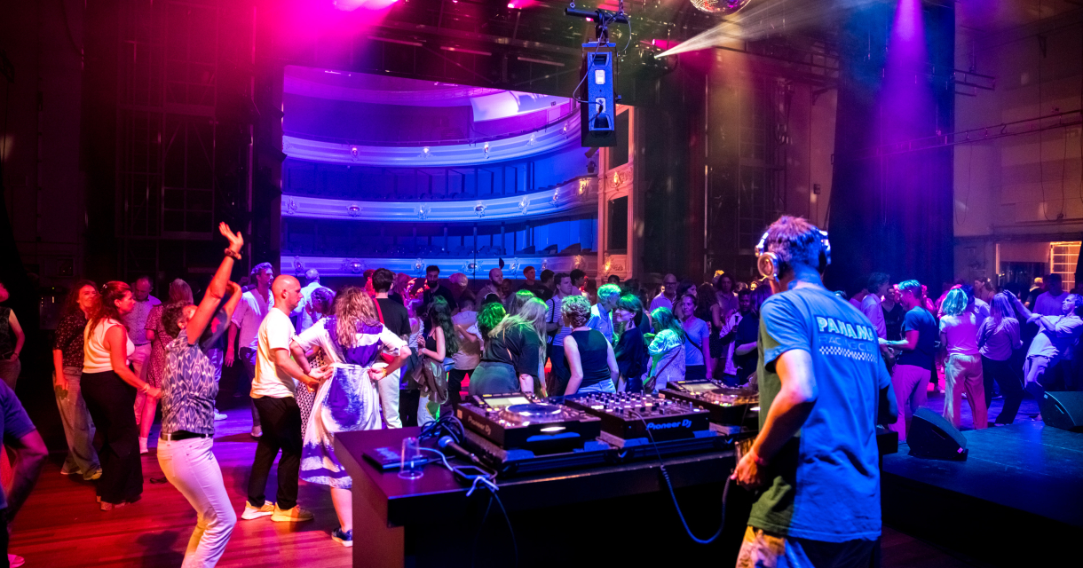 Dansende mensen met DJ achter draaitafel Dansende mensen met DJ achter draaitafel