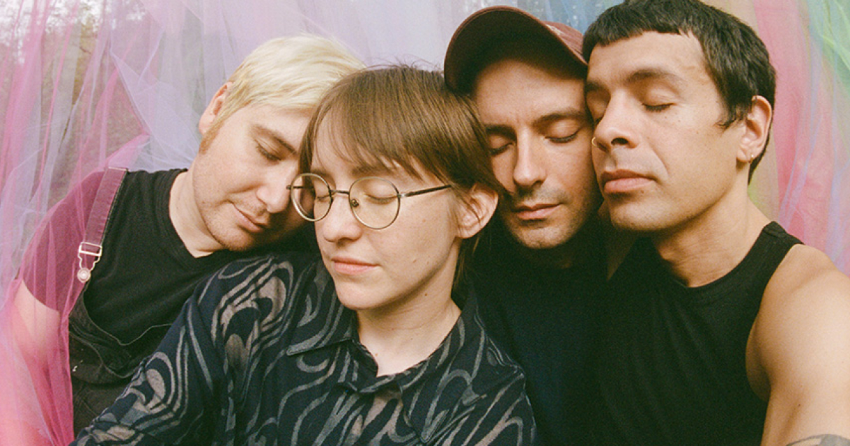 New Yorkse indiefolk bandleden leunend tegen elkaar met dichte ogen voor kleurrijke voile gordijnen. New Yorkse indiefolk bandleden leunend tegen elkaar met dichte ogen voor kleurrijke voile gordijnen.