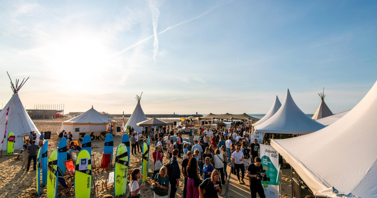 Sfeerbeeld van event Impact on the beach met publiek op strand en witte tenten. Sfeerbeeld van event Impact on the beach met publiek op strand en witte tenten.