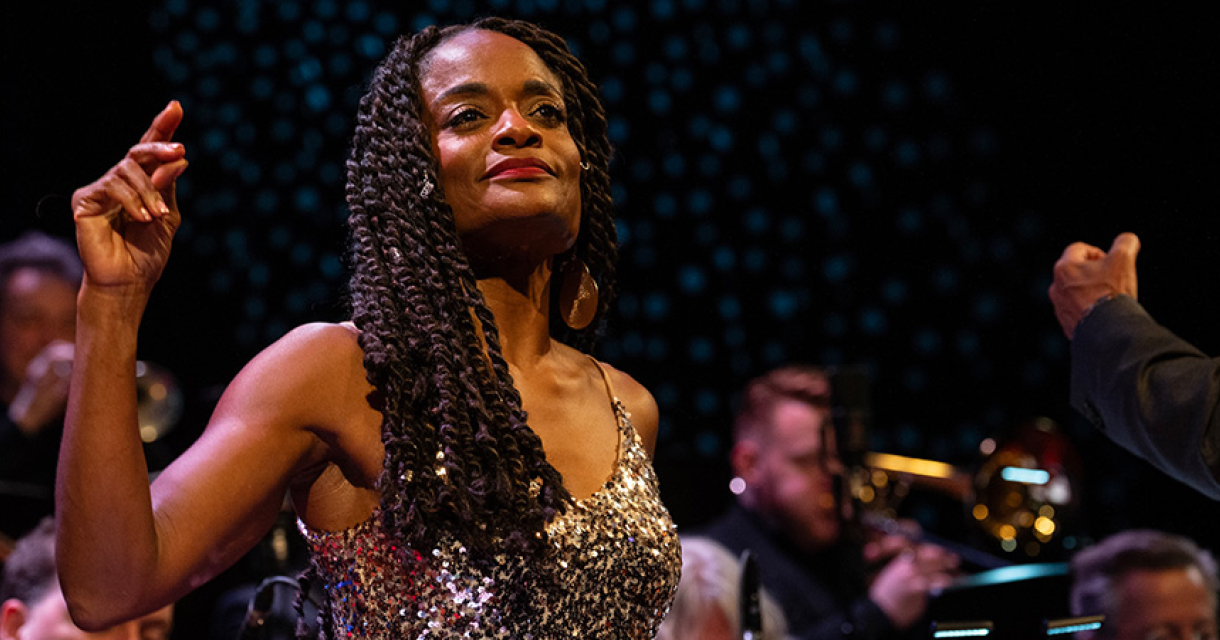 Foto van Izaline Calister dansend op podium in glittertop