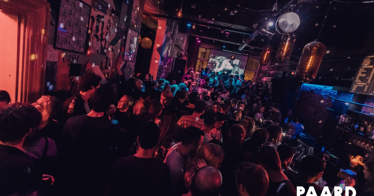 Drukke dansvloer in het Paardcafé in Den Haag, met feestende mensen, kleurrijke verlichting en een levendige sfeer. Drukke dansvloer in het Paardcafé in Den Haag, met feestende mensen, kleurrijke verlichting en een levendige sfeer.