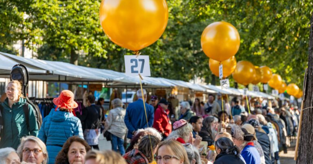 Drukke marktkramen en mensen zittend aan tafel voor het PrinsjesOntbijt