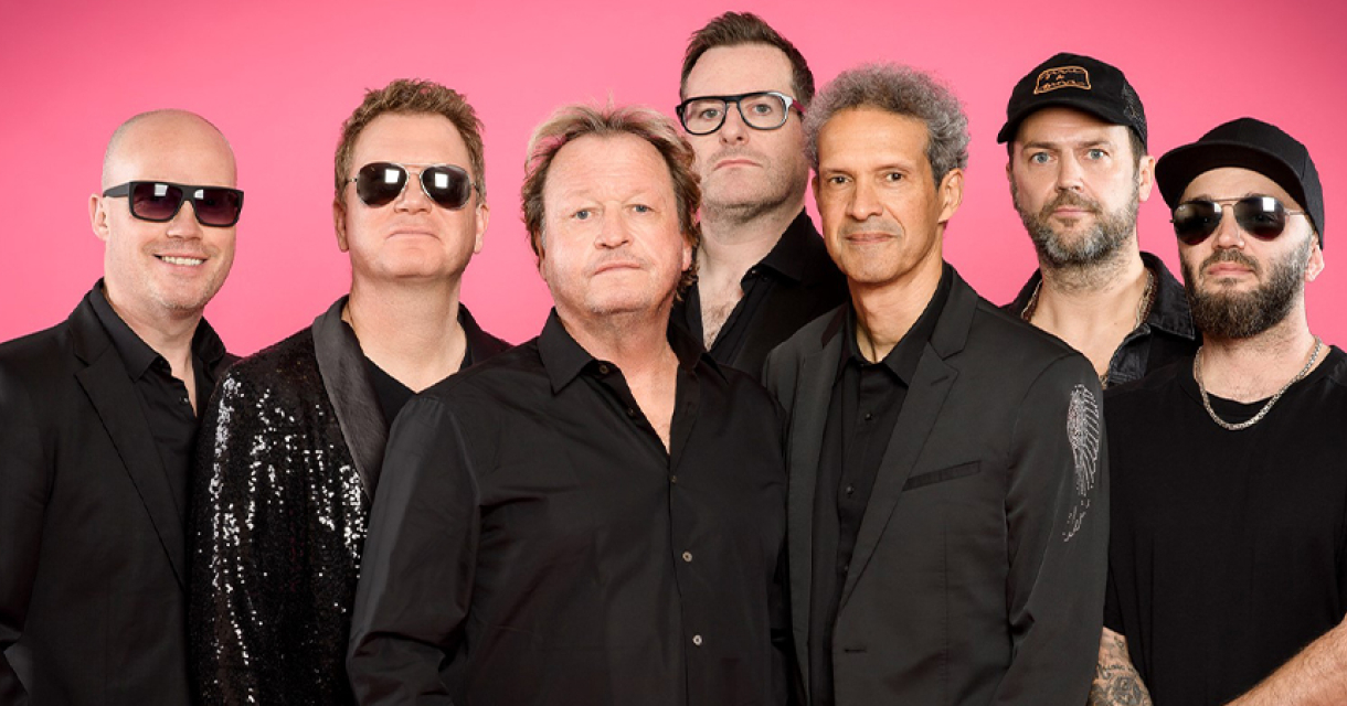 Level 42 band in zwart gekleed met roze achtergrond. Level 42 band in zwart gekleed met roze achtergrond.