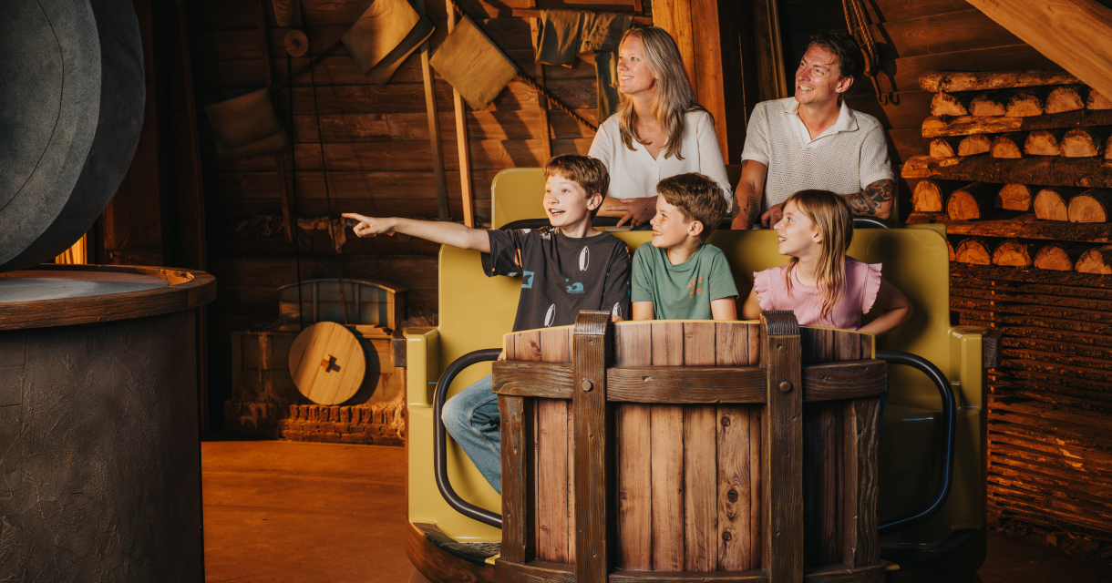 gezin met 2 jongens en een meisje in een attractie wagon in de vorm van een houten ton. gezin met 2 jongens en een meisje in een attractie wagon in de vorm van een houten ton.