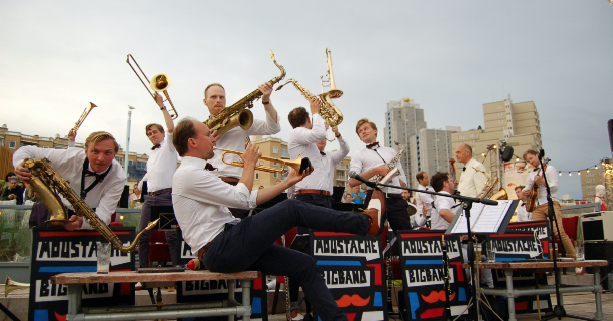 Moustache Big Band op bankjes Scheveningen spelend op instrumenten. Moustache Big Band op bankjes Scheveningen spelend op instrumenten.