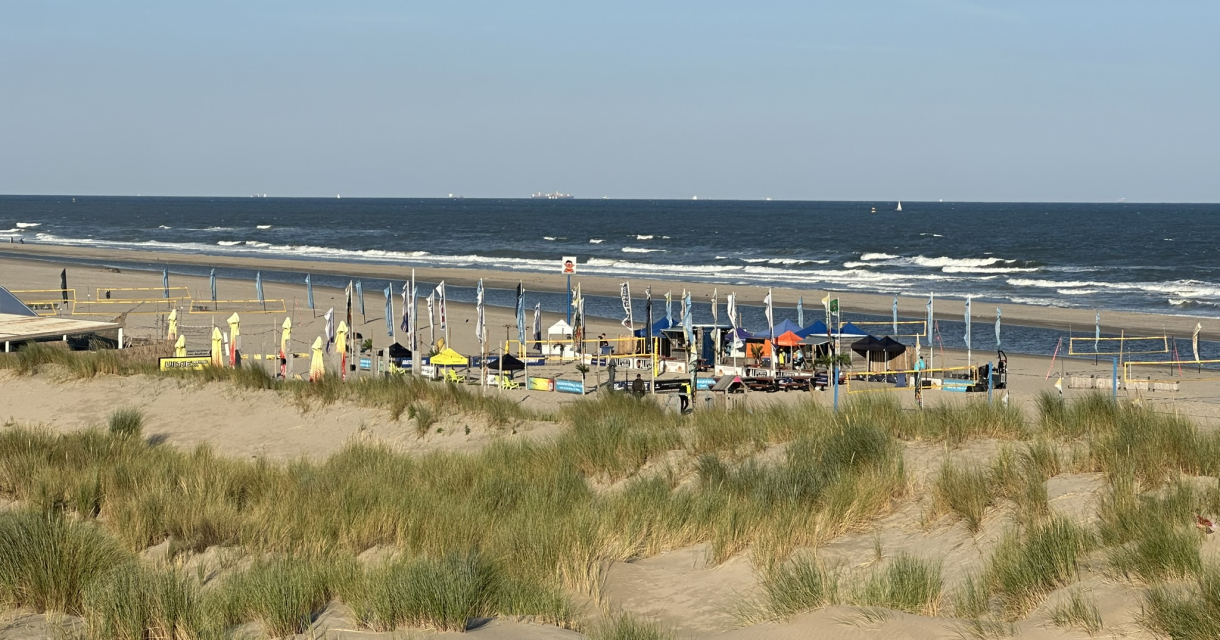 Zicht vanaf de duinen Kijkduin op het strand met de volleybalnetten.