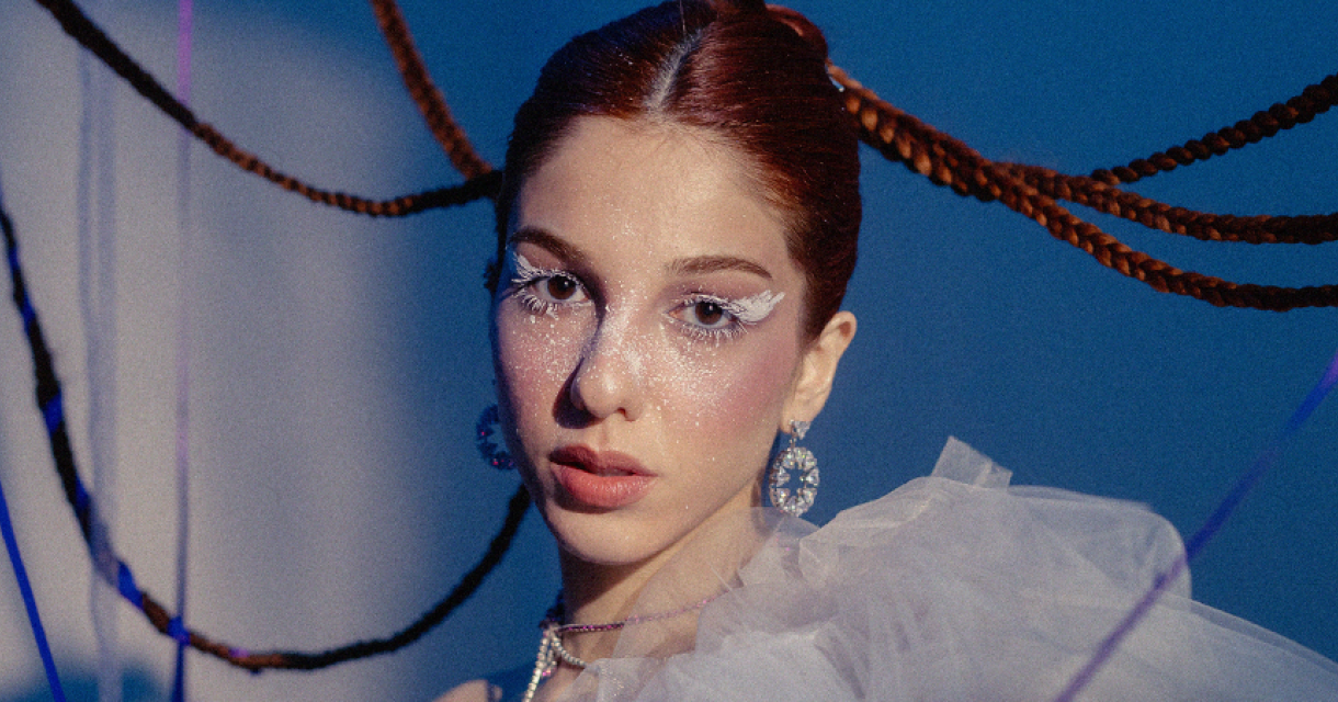 SInger songwriter Selin met feestelijke glitter make up en haar vlechten dansen als feestslingers achter haar hoofd.