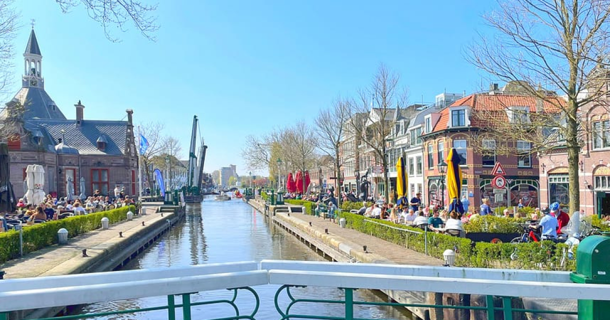 Zonnige dag bij de sluis van Leidschendam met volle terrassen, historische panden en blauwe lucht aan het water. Zonnige dag bij de sluis van Leidschendam met volle terrassen, historische panden en blauwe lucht aan het water.