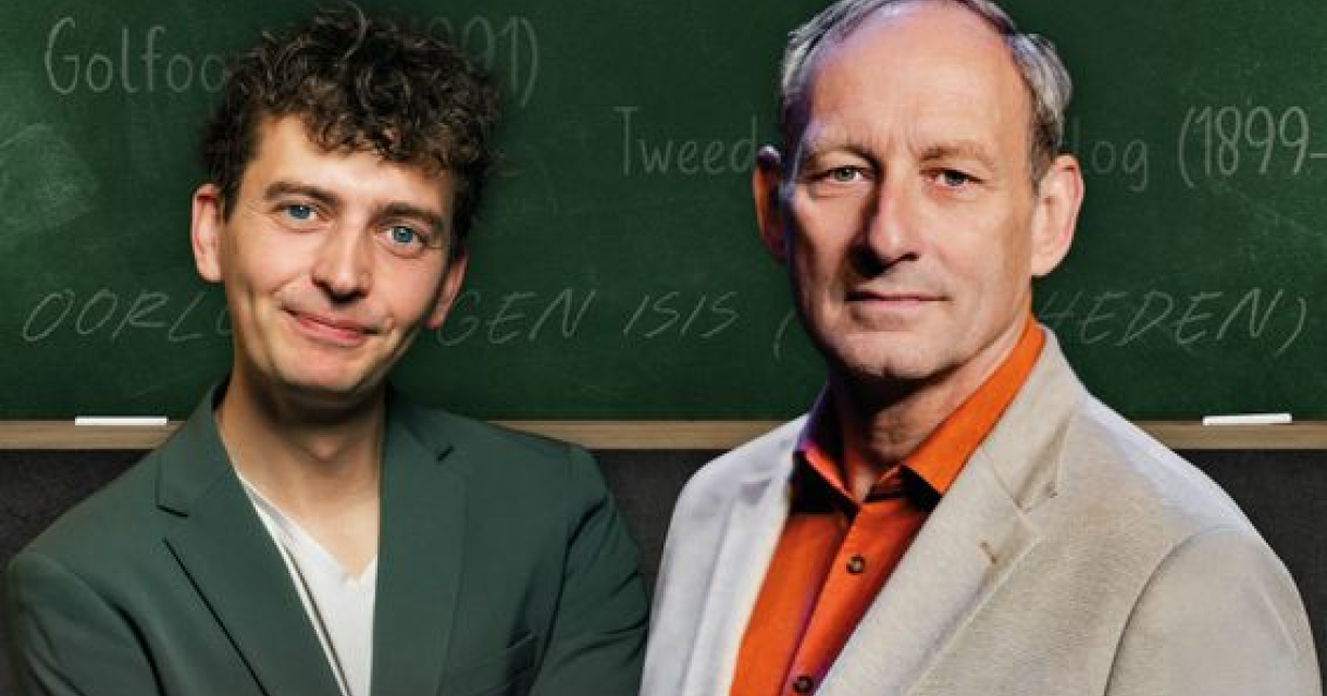 Twee mannen voor een schoolbord met historische termen, beiden kijken recht in de camera