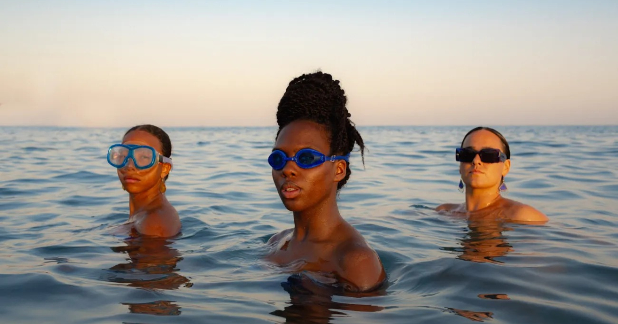 Promotiebeeld voor voorstelling diep: 3 vrouwen staan tot hun schouders in de zee. Twee dragen een duikbril de derde een zonnebril. Promotiebeeld voor voorstelling diep: 3 vrouwen staan tot hun schouders in de zee. Twee dragen een duikbril de derde een zonnebril.