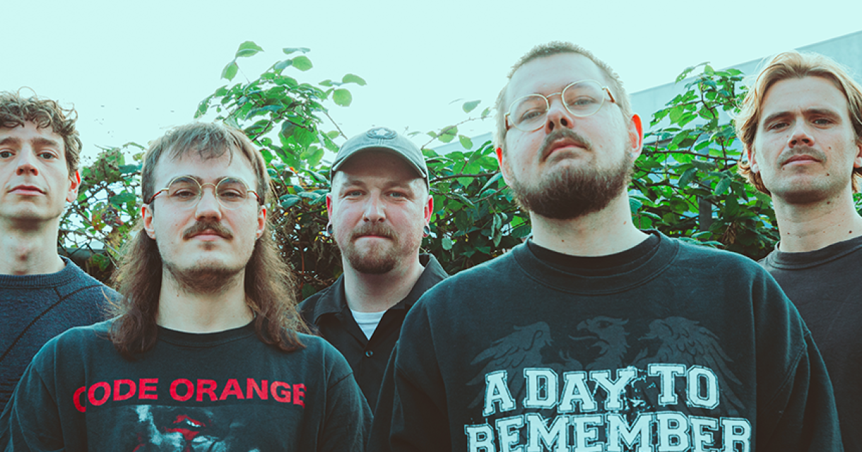 Bandfoto van melodic hardcore band I’ll Get By met bandshirts aan serieus kijkend in de lens buiten voor een boom