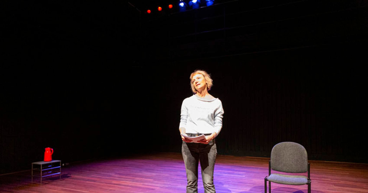 Vrouw op toneel met script in spotlight